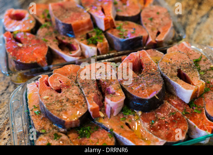 Le coho frais (argent) darnes de saumon de l'Alaska, la marinade avant de les griller Banque D'Images