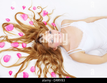 Jolie fille avec des pétales de rose dans ses cheveux Banque D'Images