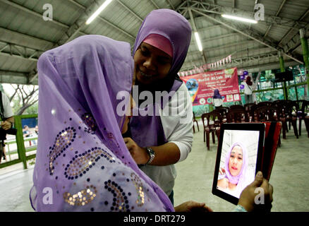 Quezon, Philippines. 1er février, 2014. Dr Claire Bermundo un catholique s'adapte son hijab au cours de la journée mondiale de Hijab à Quezon City le 1 février 2014. Dans monde Hijab day, les femmes des pays musulmans et non musulmans les femmes sont invitées à porter le hijab (voile) pour une journée pour promouvoir la tolérance religieuse et de comprendre pourquoi les femmes musulmanes portent le hijab. Credit : Mark Fredesjed Cristino/Alamy Live News Banque D'Images