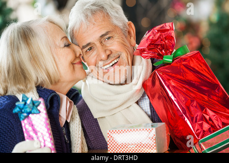 Femme sur le point de baiser Man Holding Christmas Presents Banque D'Images