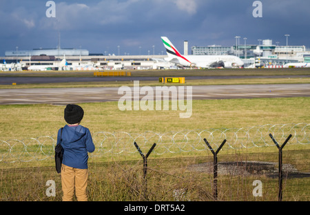 Jeune garçon regardant les avions à l'aéroport de Manchester Banque D'Images