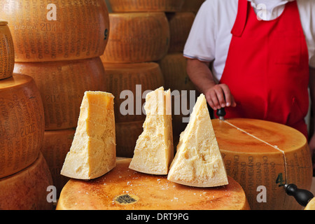 Couper des morceaux et les roues de Parmesan - fromage italien fabriqué à partir de lait cru de vache. Banque D'Images
