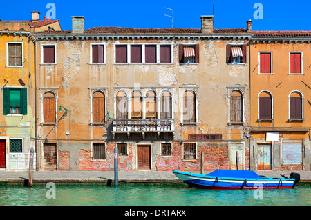 Vieille maison de briques colorées typiques, des volets sur les fenêtres et petit canal à Venise, Italie. Banque D'Images