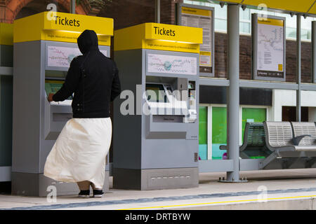 Passager achetant des billets de tramway au New transport Link d'Oldham Central. L'expansion de Metrolink se poursuit avec des services qui s'exécutent maintenant dans le centre-ville d'Oldham, avec quatre nouveaux arrêts ajoutés à la ligne Oldham Rochdale. Cette extension de 14 miles (22.5 km), jusqu'à Oldham et Rochdale, quitte la ligne Bury Metrolink juste à l'extérieur du centre-ville et longe le couloir ferroviaire abandonné jusqu'à Central Park dans East Manchester. Banque D'Images