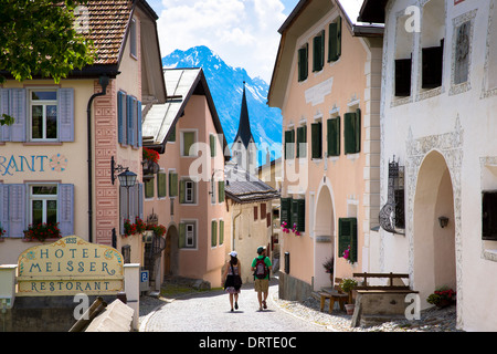 Les touristes passent Hôtel Meisser en Engadine Valley village de Guarda, bâtiments du xviie siècle en pierre peinte, Suisse Banque D'Images