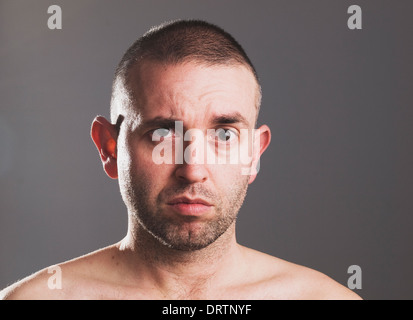 L'homme élève son sourcil de surprise expression et isolé sur fond gris. Banque D'Images