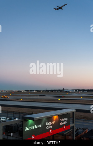 Le crépuscule s'installe au-dessus de l'aéroport international d'Atlanta alors qu'un jet de passagers prend le ciel à Atlanta, en Géorgie. (ÉTATS-UNIS) Banque D'Images