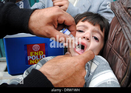 (140202) -- PESHAWAR, le 2 février 2014 (Xinhua) -- un agent de santé pakistanais contre la poliomyélite donne à un enfant au cours d'un porte-à-porte, campagne de vaccination dans le nord-ouest de Peshawar au Pakistan, le 2 février 2014. (Xinhua/Umar Qayyum) Banque D'Images