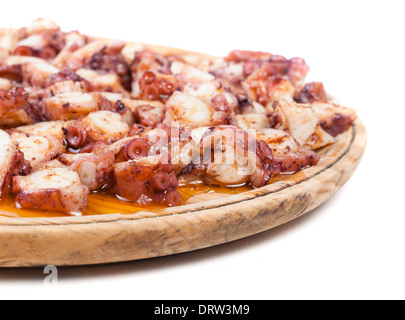 Pulpo a feira en une plaque de bois et isolé sur fond blanc Banque D'Images