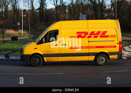 Un DHL van voyager autour d'un rond-point à Coulsdon, Surrey, Angleterre. Banque D'Images