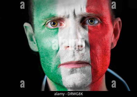 Un regard intense d'un supporter de football avec leur visage peint avec le drapeau italien. Banque D'Images