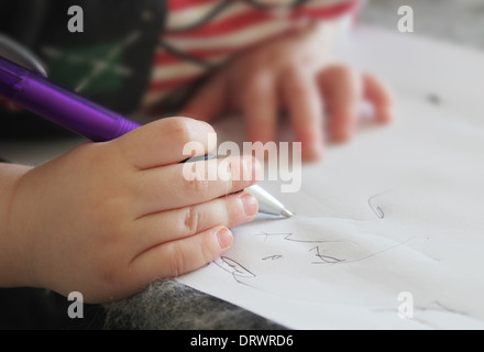 Petit enfant écrit la main dans le bloc-notes Banque D'Images