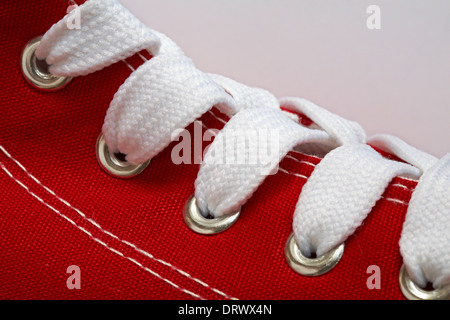 Close up de lacets et oeillets métalliques sur toile bottes rouge Banque D'Images