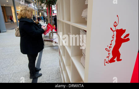 Berlin, Allemagne. 06Th Feb 2014. Une femme regarde le programme Berlinale avant le 64e Festival du Film de Berlin, à Berlin, Allemagne, 03 février 2014. La Berlinale 2014 se déroule du 06 au 16 février. Photo : TIM BRAKEMEIER/dpa/Alamy Live News Banque D'Images