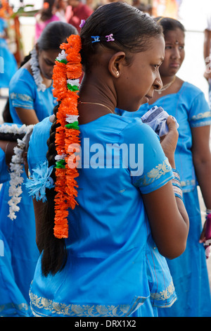 Une jeune fille en robe bleue avec guirlande dans ses cheveux pendant le festival religieux thaipoosam, Maurice. Banque D'Images