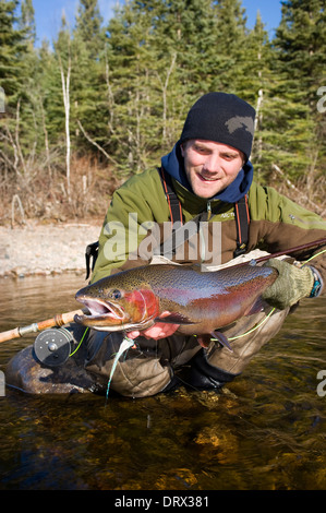 Tenant un grand pêcheur à la truite arc-en-ciel pris spey casting dans une rivière dans le Nord de l'Ontario, Canada Banque D'Images