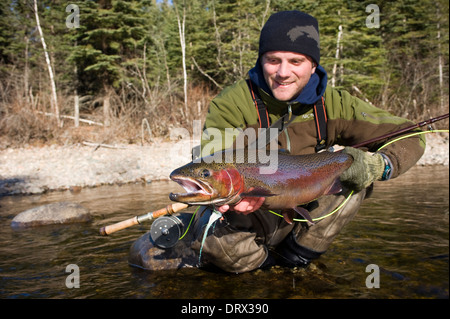 Tenant un grand pêcheur à la truite arc-en-ciel pris spey casting dans une rivière dans le Nord de l'Ontario, Canada Banque D'Images