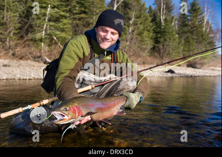 Tenant un grand pêcheur à la truite arc-en-ciel pris spey casting dans une rivière dans le Nord de l'Ontario, Canada Banque D'Images