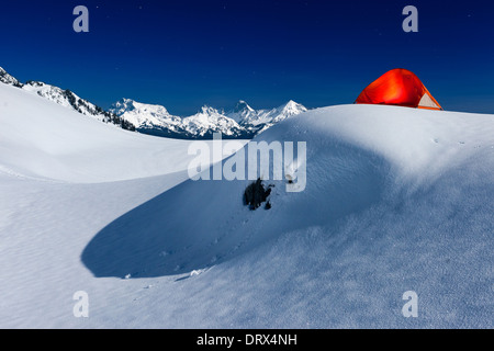 Glowing tente sous le clair de lune sur la montagne de neige Banque D'Images