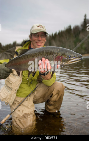 Tenant un grand pêcheur à la truite arc-en-ciel pris spey casting dans une rivière dans le Nord de l'Ontario, Canada Banque D'Images