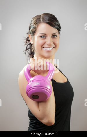 Jolie femme sportive holding kettlebell Banque D'Images