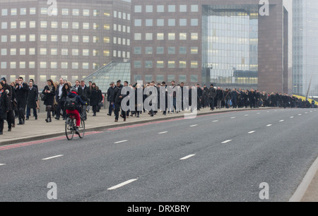 Les employés de bureau à pied à travers le pont de Londres sur le chemin de la ville, Londres Angleterre Royaume-Uni UK Banque D'Images