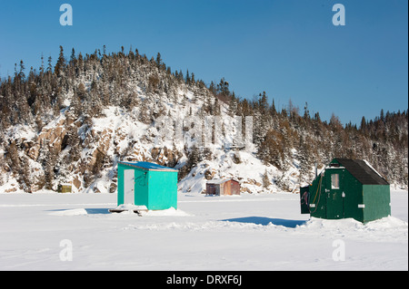 Cabanes de pêche sur glace sur un lac gelé dans le Nord de l'Ontario. Banque D'Images