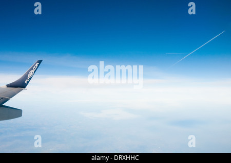 Tourné à partir de la fenêtre de l'avion, montrant flyniki.com logo sur aile d'avion, dans des tons de bleu ciel nuageux et les traînées d'avions dans le dos Banque D'Images