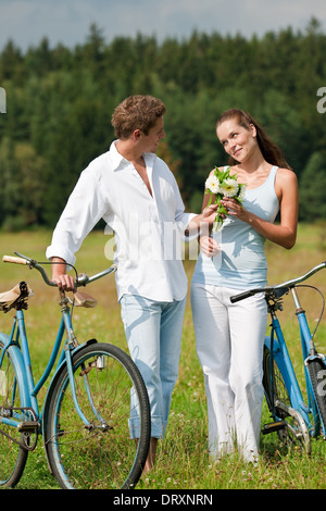 Jeune couple romantique balade avec vieux vélo Banque D'Images