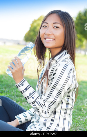 Portrait d'une jeune fille asiatique dans un parc avec une bouteille d'eau Banque D'Images