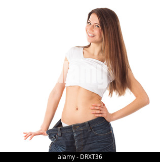 Cheerful young woman showing sa taille par le port d'un vieux jeans, isolated on white Banque D'Images