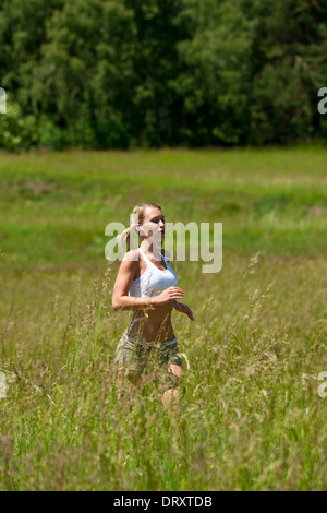 Young woman jogging dans un pré Banque D'Images