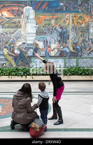 Detroit, Michigan - Un docent raconte les visiteurs sur Diego Rivera's Detroit 'Industrie' murales au Detroit Institute of Arts. Banque D'Images