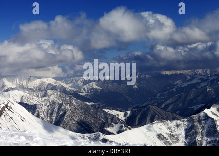 Montagnes hiver au soleil dans les nuages, vue à partir de la pente de hors-piste. Montagnes du Caucase, la Géorgie, ski de Gudauri. Banque D'Images