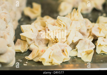 Fabrication d'une insouciance déréglée ou wantan, un chinois quenelles. Banque D'Images