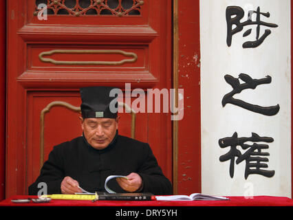 Beijing, Chine, Chine. Jan 31, 2014. Un moine taoïste inspecte les billets comme lumière chinois d'encens et prier à la Dongyue temple Taoïste le premier jour de la nouvelle année lunaire de la Chine à Beijing le 31 janvier 2014. Selon le calendrier lunaire chinois, la Chine se félicite de l'année du cheval le 31 janvier. Le cheval, classé septième parmi les 12 animaux sur le zodiaque chinois, est l'un des signes les plus aimés comme il est largement considéré comme un symbole de la force et de la vitesse. © Stephen Shaver/ZUMAPRESS.com/Alamy Live News Banque D'Images