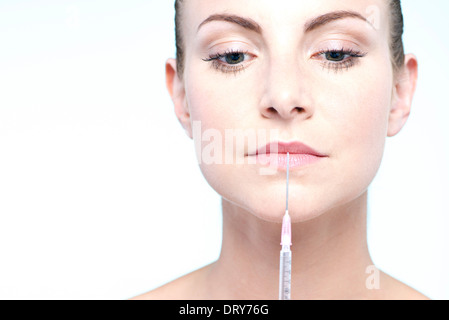 Woman holding up syringe Banque D'Images