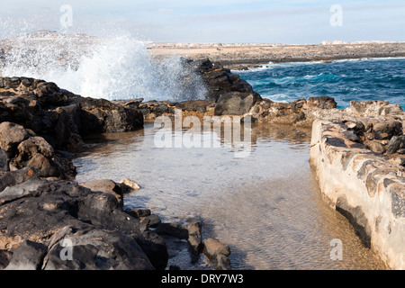 Écume de mer à marée haute sur la rupture dans le trou du bassin de collecte de souffler au musée du sel (Museo de la Sal), Fuerteventura Banque D'Images