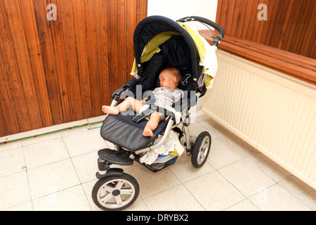 Bébé dormant dans une poussette tout-petit aloneAlone Banque D'Images