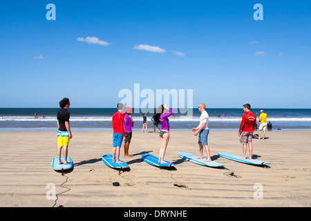 Surfers apprendre à surfer sur la plage prêt pour une leçon de surf à une école de surf sur la plage de Playa Tamarindo en Guanacaste. Banque D'Images