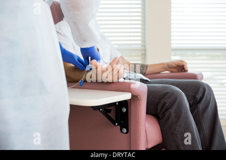 Réglage de l'infirmière Perfusion IV sur la main du patient dans la salle de chimio Banque D'Images