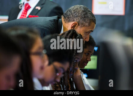 Adelphi, Maryland, USA. Le 04 février, 2014. Le président des États-Unis Barack Obama se penche sur l'écran de l'ordinateur sur les épaules de septième année dans une classe qui utilise la technologie pour améliorer l'apprentissage, avant de délivrer les remarques sur l'Initiative connecté à Buck Lodge Middle School à Adelphi, Maryland, USA, 04 février 2014. Le Président Obama est connecté à l'initiative de réunir toutes les écoles dans l'ère du numérique avec la technologie sans fil et à large bande. Crédit : JIM LOSCALZO /extérieure via CNP/dpa/Alamy Live News Banque D'Images