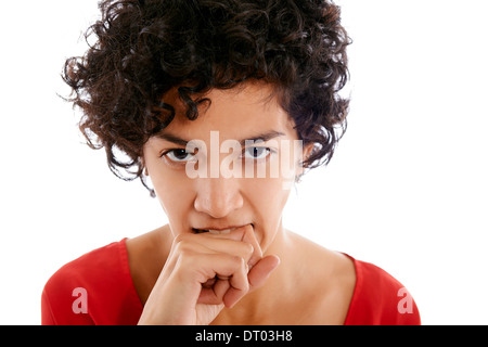 Hispanic woman biting frustré les doigts, en colère, looking at camera Banque D'Images