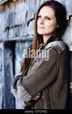 Young Beautiful woman leaning on a log cabin et pensée Banque D'Images