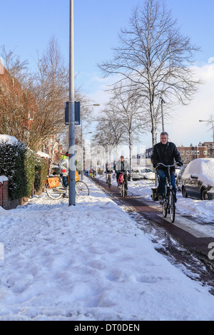 Cycliste personnes sur les pistes cyclables à travers la neige pour leur travail dans l'hiver Banque D'Images