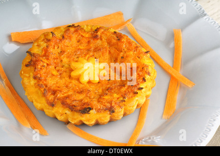 Mini quiche végétarienne avec carottes servi sur une assiette de porcelaine gris Banque D'Images