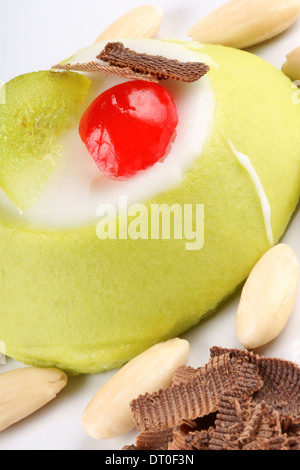 Mini Cassata Sicilienne avec amandes et copeaux de chocolat sur une assiette blanche. Banque D'Images