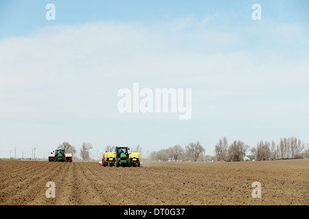 Tracteurs et autres machines agricoles travaillant dans les domaines de la plantation célèbre Pommes de terre Idaho. Banque D'Images