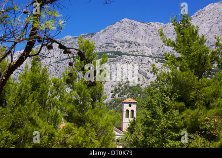 Église dans vieux village de Tucepi ci-dessous de hautes montagnes d'Biakovo nature park sur la Riviera de Makarska en Dalmatie, Croatie Banque D'Images