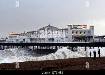 Brighton, Sussex. UK. 5e février 2014. La jetée de Brighton prend un coups de haute mer lors des coups de vent le long de la côte sud de l'Angleterre alors que trois personnes sont dangereusement près de l'eau. Banque D'Images